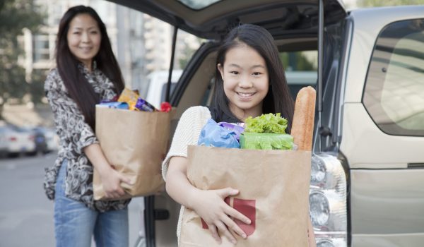 Chinese mother and daughter unloading groceries from car